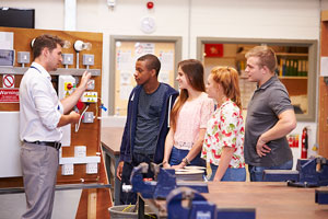 Man talking to 4 students listening on